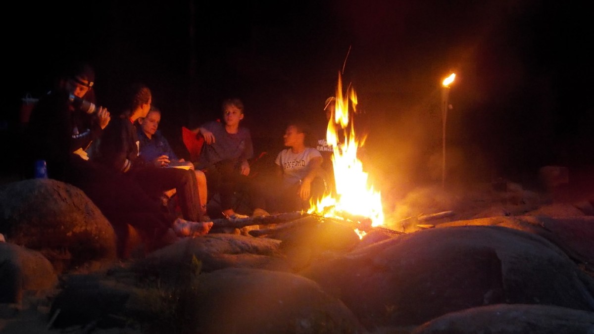 a group of people sitting around a fire